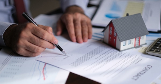Man signing a mortgage contract of a sale for a new house